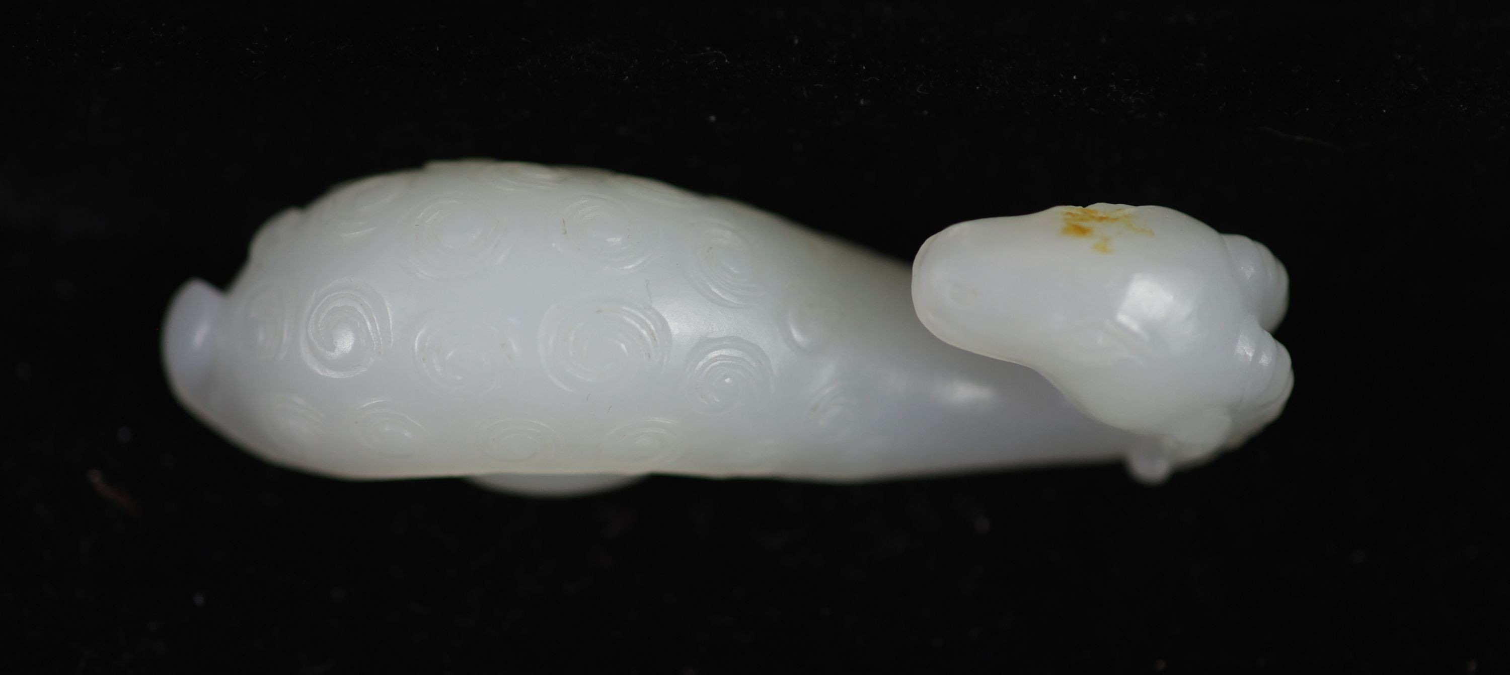 A Chinese white jade 'ram’s head’ belt hook, 6.4 cm long